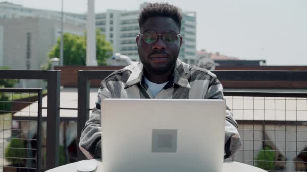 Fiatal Fekete Szemüveges Férfi Aki Kültéri Laptoppal Dolgozik Városi Épületek — Stock videók