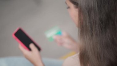 İnternetten akıllı telefondan alışveriş. Ödemeyi yapmak ve kredi kartı bilgilerini girmek için kız