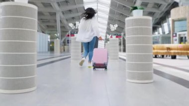 Bagajı olan bir kadının yavaş çekim çekimi. İstasyonda koşan bayan yolcu trene geç kalmasın.