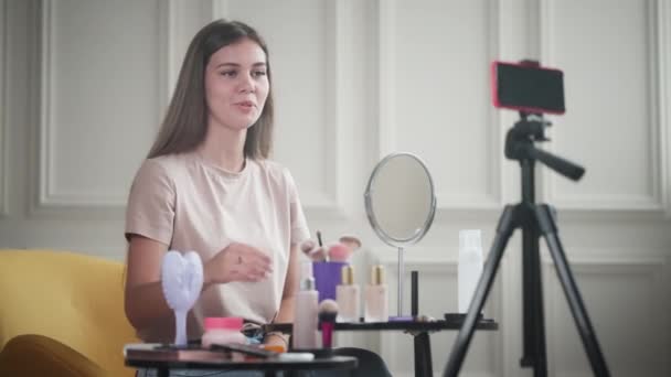 漂亮的年轻女子给一些关于化妆品的建议 在她的美丽博客中 她谈论化妆品基金会 — 图库视频影像