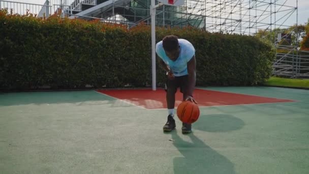 非洲裔美国人篮球运动员在室外场地上练习 并进行固定的运球练习 以提高技术和慢动作 — 图库视频影像
