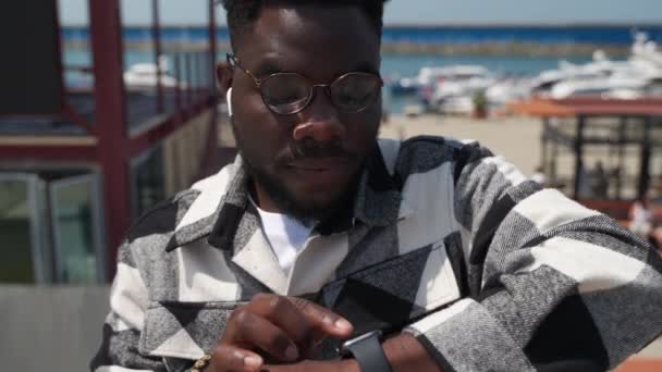 Junger Afroamerikanischer Mann Draußen Kai Scrollt Die Kontakte Oder Nachrichten — Stockvideo