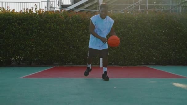 一位非洲裔美国篮球运动员在阳光下在球场上运动时的慢镜头前镜头 运动员练习提高控球和运球技巧 — 图库视频影像