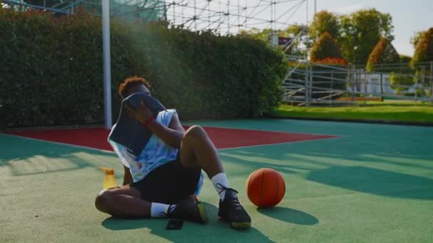 Втомився Афроамериканський Спортсмен Відпочиває Баскетбольному Майданчику Після Тренування Спекотний Літній — стокове відео