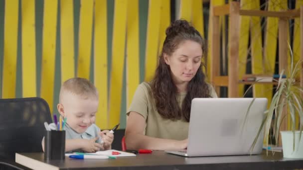 Szczęśliwa Matka Pracuje Zdalnie Laptopem Domu Siedzi Swoim Synkiem Wolnym — Wideo stockowe