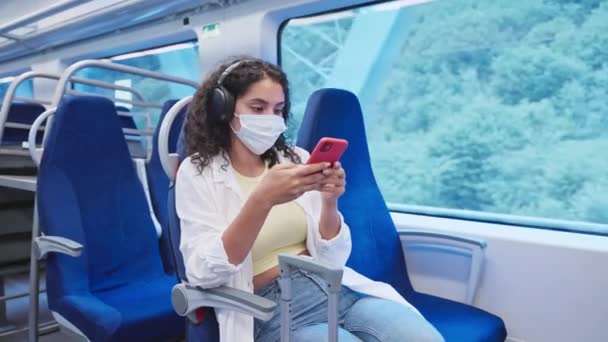 Νεαρή Γυναίκα Προστατευτική Μάσκα Προσώπου Ταξιδεύει Τρένο Χρησιμοποιώντας Smartphone Και — Αρχείο Βίντεο
