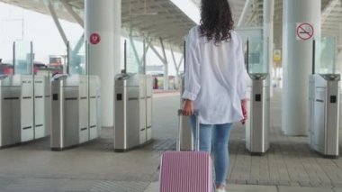 Bavullu kadın tren istasyonunda turnikeden geçiyor, trenle seyahat ediyor, vurulan kadın yolcuları takip ediyor, güvenlik kapısı, platformdaki bagajlı genç bayanın arka camı.