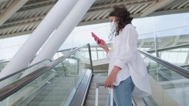 Kobieta Maską Twarzy Sprawdza Rozkład Jazdy Lotniska Lub Dworca Kolejowego — Wideo stockowe