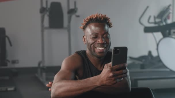 Deportista Negro Usando Teléfono Gimnasio Atleta Masculino Descansando Después Del — Vídeos de Stock