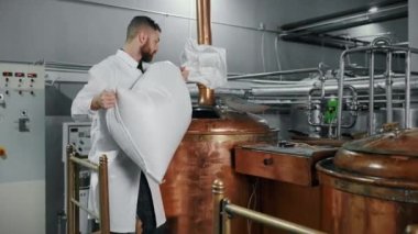 Fabrika işçisi yiyecek işleme tankına malzeme boşaltıyor. Gıda üretim tesisleri
