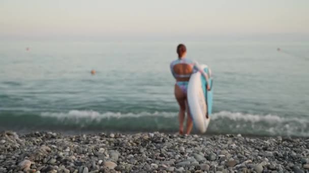 Rückenaufnahme Einer Frau Die Ein Aufblasbares Surfbrett Trägt Und Ins — Stockvideo