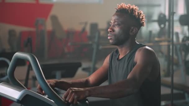 Fokuserad Svart Idrottsman Tränar Gymmet Kardioträning Motionscykel Regelbunden Sportaktivitet För — Stockvideo