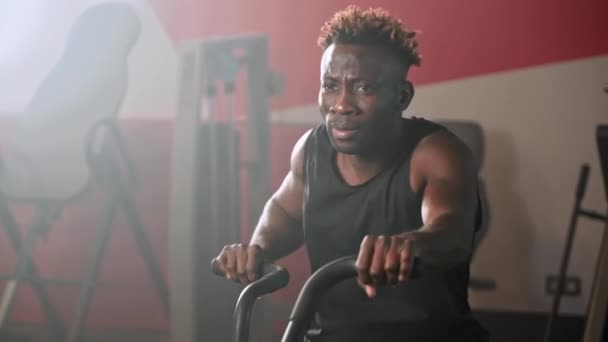 Atletyczny Afroamerykanin Człowiek Jest Przędzenia Pedały Roweru Treningowego Siłowni Hard — Wideo stockowe