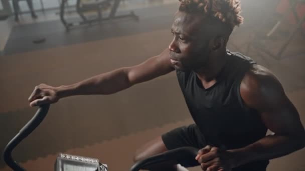 Kaslı Kolları Olan Atletik Siyah Adam Sabit Bisiklet Spor Aletleri — Stok video