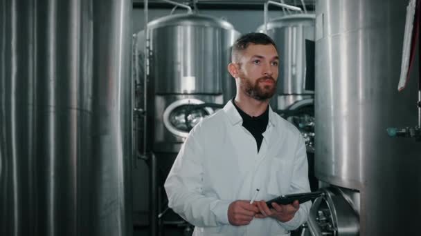 生产现代食品和饮料的车间 技术专家行走在圆柱形圆锥罐 啤酒或葡萄酒生产厂的现代设备之间 — 图库视频影像