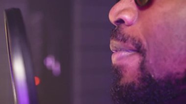 Afrika kökenli Amerikalı profesyonel erkek şarkıcının ses geçirmez müzik stüdyosunda şarkı kaydettiği aşırı yakın çekim.