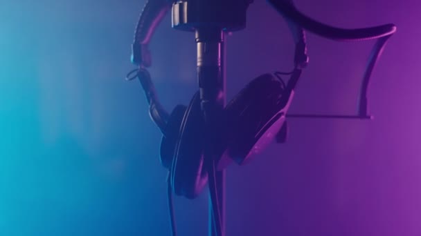 Álljon Mikrofonnal Fejhallgatóval Professzionális Audio Stúdióban Kék Lila Homályos Fényben — Stock videók
