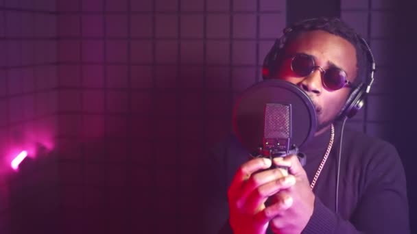 一个黑人歌手拿着话筒在录音室里唱他的情歌时的慢镜头 专业音乐制作 — 图库视频影像
