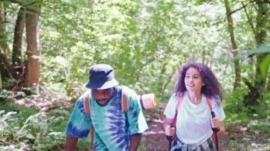Yazın ormanda yürüyüş yapan iki turist, gülümseyen çok ırklı erkek ve kadın portresi, hafta sonu gezisinde eğlenen genç insanların aktif hobileri ve spor yaşam tarzları