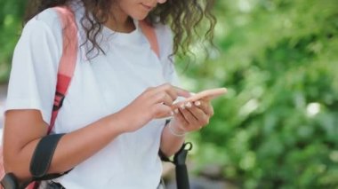 Ormanda seyrüsefer için elektronik haritalı akıllı telefon kullanan kadın sırt çantalı, modern mobil mobil aygıtın dokunmatik ekranını çalan mobil uygulama kullanıcısı
