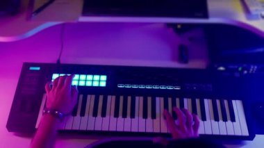 Ses stüdyosunda synthesizer ile çalışan insan besteci, el görünümü dijital klavyedeki tuşlara basıyor