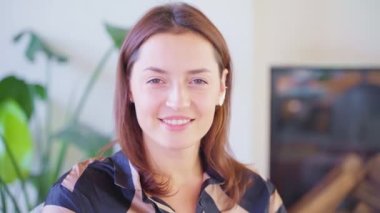Kameraya bakıp gülümseyen güzel yetişkin bir kadının portresi makyajsız ve estetik ameliyatsız doğal bir kadın güzelliği sağlıklı beyaz dişler ve yetişkin bir kadının gülümsemesi, güzel bir kadın yüzü.