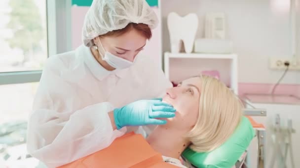 歯科の若い白人女性のための歯科医の歯科検査 口を開いた状態の椅子に座っている患者は 医師が彼女の歯をチェックしています ストロマトロジークリニック 検査コンセプト — ストック動画