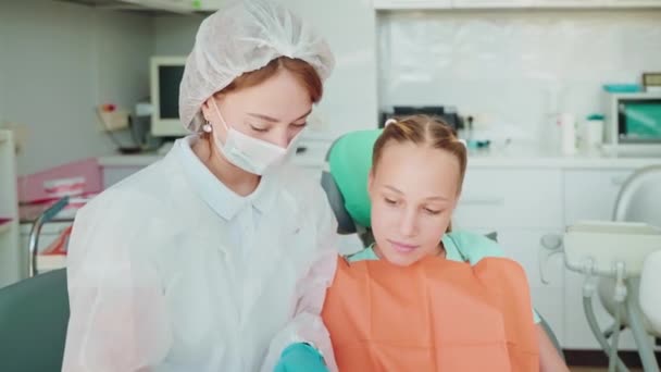 Chica Adolescente Cita Con Dentista Médico Que Muestra Aprendizaje Vídeo — Vídeos de Stock