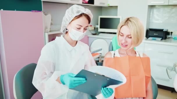 Tandläkare Och Blond Kvinna Läser Och Förklarar Tillsammans Kontrakt Inom — Stockvideo