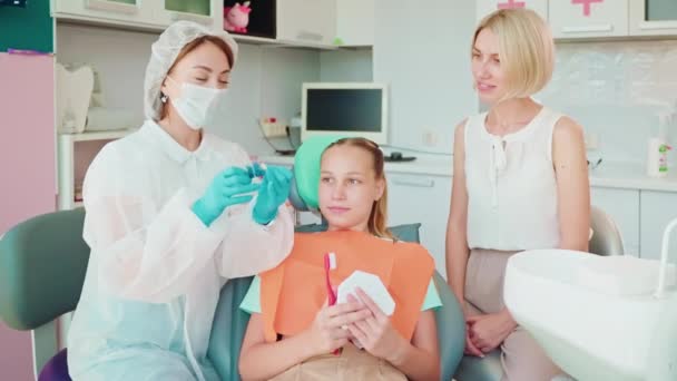 Dentista Mulher Explicando Ensinando Adolescente Paciente Menina Sua Mãe Consultório — Vídeo de Stock