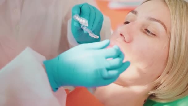 牙齿矫正师安装可摘除的透明牙槽 在牙科诊所为妇女保留牙槽 面对特写 口腔科门诊部正畸治疗的口腔学家 牙齿对齐程序 — 图库视频影像