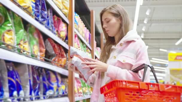Молодая Женщина Покупает Чипсы Продуктовом Магазине Принимает Пакеты Нездоровой Канцерогенной — стоковое видео