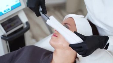 Kozmetik uzmanı estetik tıp kliniğinde yüz tedavisi sunuyor ve cildin fotorejuvenizasyonu için BBL lazeri kullanıyor. Lazer kızarıklığı, güneş hasarını, yaşlanmayı önler.