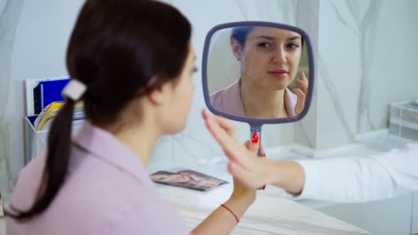 Косметолог Дает Рекомендации Уходу Лицом Женщине Которая Смотрит Зеркало Уход — стоковое видео
