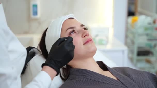 Cirurgião Plástico Marcando Rosto Feminino Com Lápis Durante Consulta Clínica — Vídeo de Stock