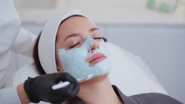 在美容院 一名妇女正享受用粘土面罩进行面部治疗的特写镜头 化妆品和温泉 — 图库视频影像