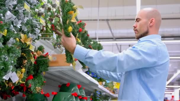 Хлопець Купує Різдвяний Вінок Супермаркеті Чоловік Вибирає Домашні Прикраси Супермаркеті — стокове відео