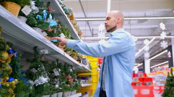 Hombre Eligiendo Pequeño Árbol Navidad Supermercado Tipo Tomando Diferentes Árboles — Vídeos de Stock