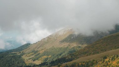 Dağlarda inanılmaz manzaralar, yağmur bulutları, dağın tepesinden manzara, tırmanış ve seyahat, doğanın resimsel güzelliği, güzel manzaraya hayran olmak.