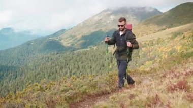 Dağın zirvesine tırmanan gezgin, dayanıklılığını ve gücünü eğitiyor, dağlarda tek başına yürüyüş yapıyor, temiz havayı soluyor ve doğanın güzelliğini tepeden seyrediyor, ekolojik alanda sırt çantasıyla geziyor.