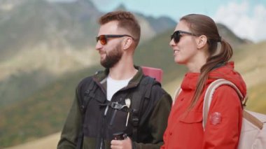 Dağlardaki erkek ve kadın yürüyüşçülerin portresi seyahati tartışıyor. Güneş gözlüklü turistler birlikte yürüyüş yapıyorlar. Gezginler tepelerdeki vahşi yerleri keşfeder. Kaşifler vahşi doğada yürüyüş güzergahını tartışıyor.