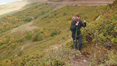 Dağlarda yürüyüş yapan bir turist vadide elinde sopalarla geziyor. Kaşif adam tepelerde geziniyor. Gezgin doğada yeni vahşi yerleri keşfediyor. Dağ zirveleri olan muhteşem bir manzara..