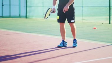 Tenisçi sahada topa vurdu. Sporcu, raket ve bacaklarla atış talimi yapıyor. Profesyonel spor antrenmanı. Açık tenis maçında antrenman. Hobi, eğlence..