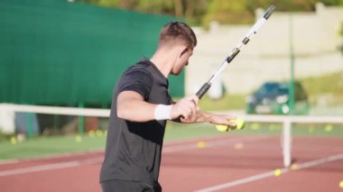Adam kortta tenis topu atışları yapıyor. Tenisçi tek başına antrenman yaparken topları vuruyor. Fiziksel egzersiz yapan profesyonel bir sporcuydum. Hobi eğlence, spor oyunları konsepti.