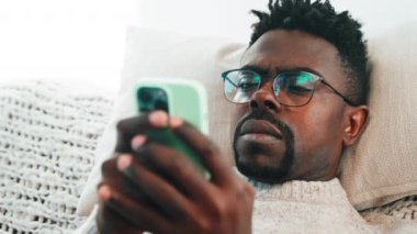 Yoğunlaştırılmış adam akıllı telefon kullanıyor, internette haberler okuyor, cep telefonlu Afrikalı Amerikalıların yakın plan portresi, online alışveriş ve sosyal medya, internet bağımlılığı