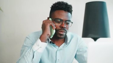 Merkez ofiste cep telefonuyla konuşan siyahi bir adam, Afrikalı Amerikalı bir iş adamının portresi ortaklarla veya müşterilerle görüşmeler, uzaktan çalışan ciddi bir adam.