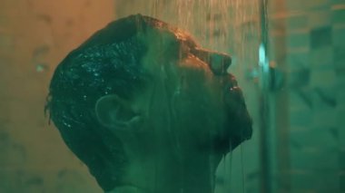 Duşta depresif bir adam, yakın çekim yüzü, yoğun bir günün ardından dinlenme depresyon ve yorgunluk, erkek kişinin başını suya sokması, akşamları hijyenik tedaviler.