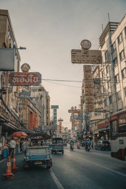Bangkok Chinatown 'daki bir römorkun içinden detaylı bir görüntü, sürücüyü yakalamak, ayna yansımaları ve hareketli sokak aktiviteleri. Sahne Tayland kentinin canlı enerjisini yansıtıyor.