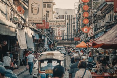 Bangkoks Çin Mahallesi 'nde hareketli caddeler, tuk-tuklar, hareketli tabelalar ve sokak satıcılarının yer aldığı canlı bir sahne. Atmosfer, yerel kültürün ve günlük yaşamın özünü yakalıyor.