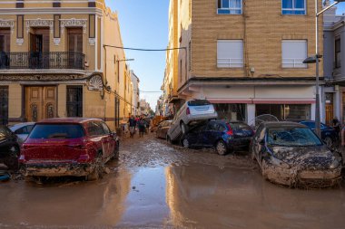 Fotoğraf Alfafar, Valencia, İspanya 'daki selin sonuçlarını gösteriyor. Gönüllüler, şiddetli sellerden sonra çamurlu bir caddeyi temizlemek için birlikte çalışıyorlar..